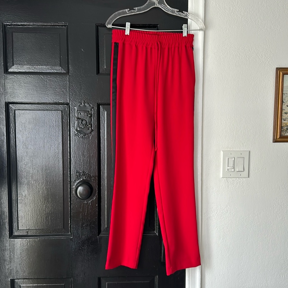 Red crepe track pants with black sport stripes